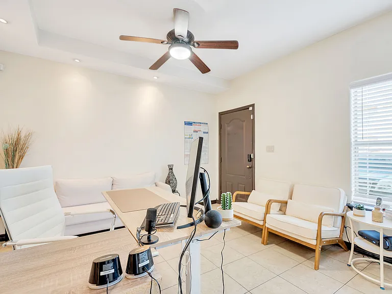 A neat office space in Merida Vista Apartments, including a desk, chair, and fan, located in Laredo, Texas
