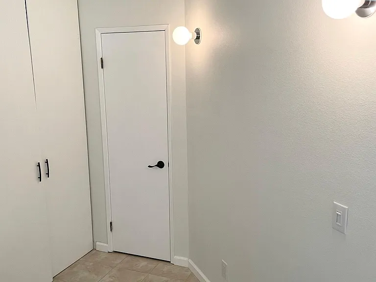 Bedroom has a closet with a built-in shelf and closet rod. Door pictured leads to bathroom.