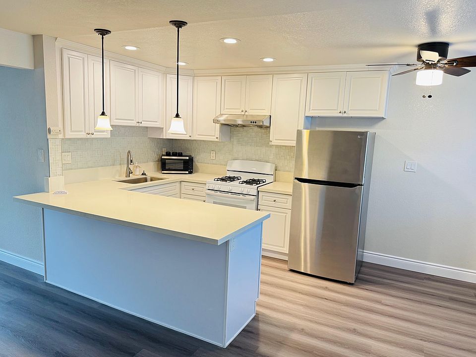 Bright kitchen with newer refrigerator and quartz countertop