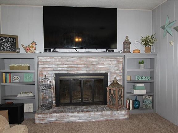 Den with wood burning fireplace.