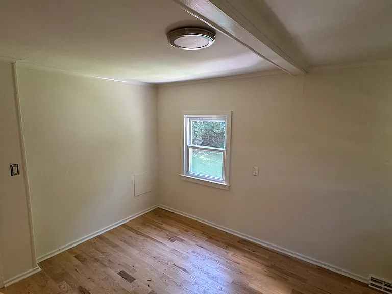 Upstairs back bedroom with wood floors.