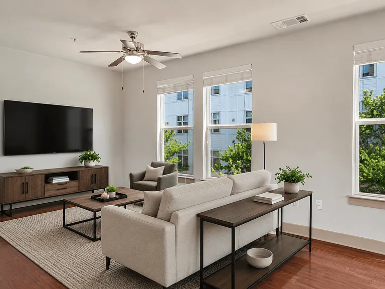 A living room with a couch, a chair, a coffee table, and a television.