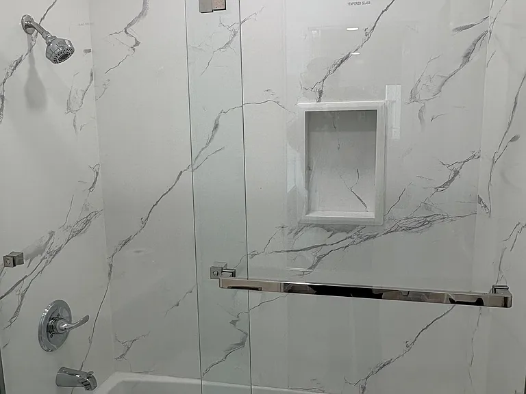 Remodeled bathroom with bathtub/shower combo with bath wall to ceiling.