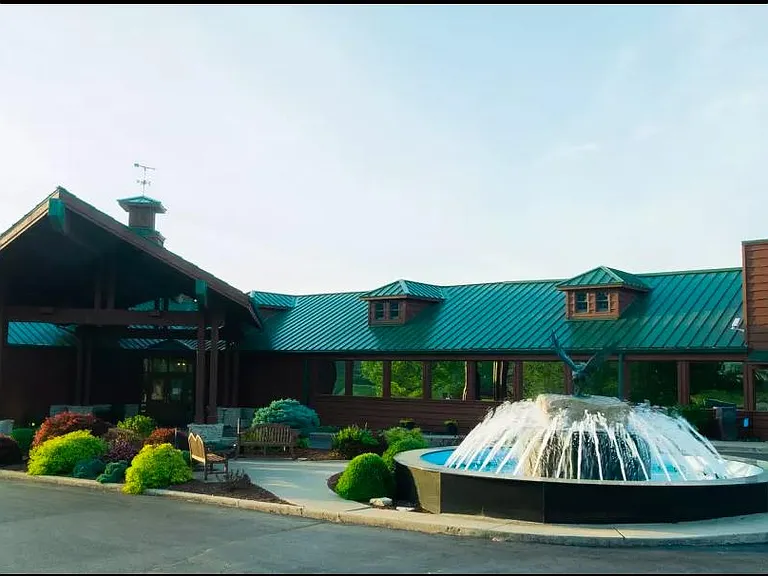 Club house. Restaurant. Golf course. Fountain near gated entrance.