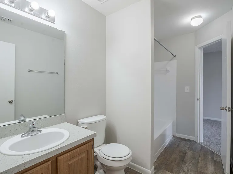 Experience elegance in this sleek modern bathroom, featuring stylish wooden cabinetry and a roomy shower.