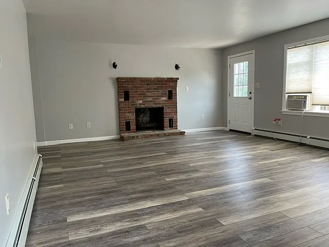 Spacious living room. Fireplace is not usable. This picture was taken before the heat pump was installed. No need for the window AC.