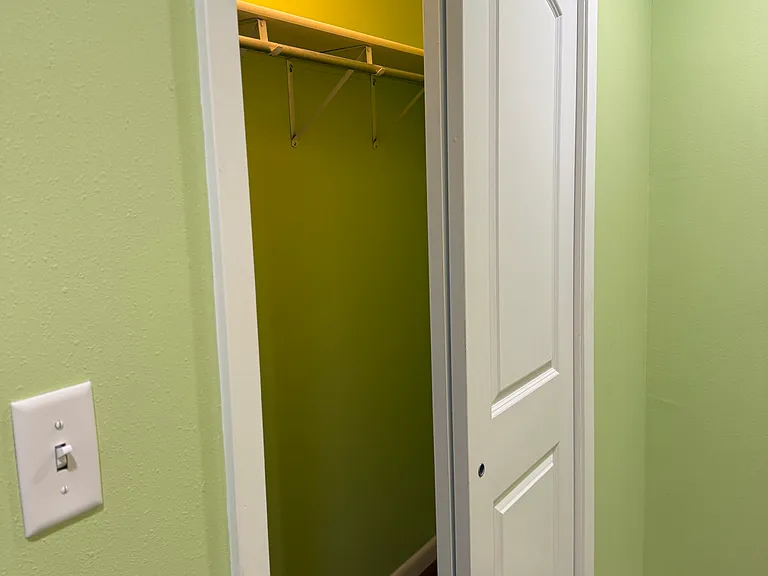 Large lighted closet in smaller bedroom.