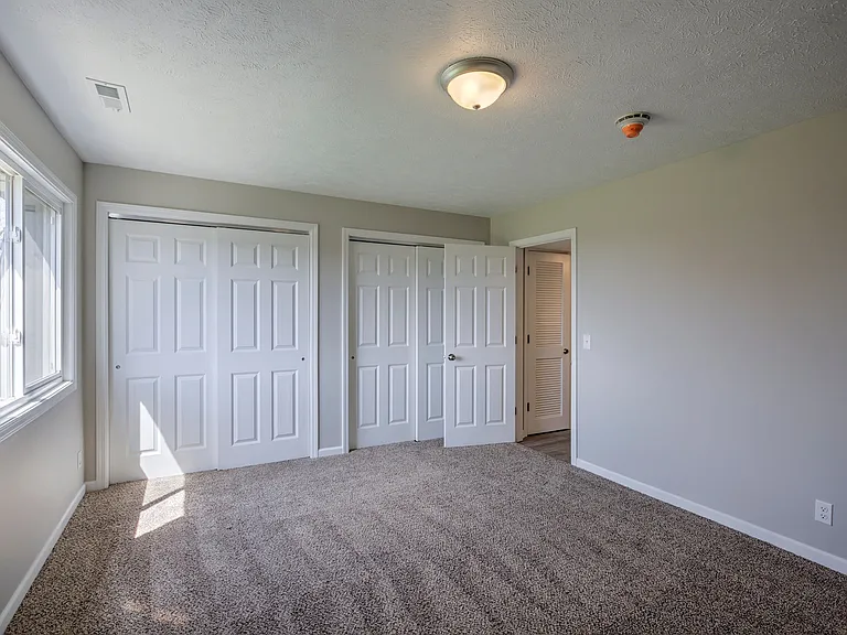 Welcome to The Pines at Q Plaza Apartments! This spacious bedroom features plush carpeting and ample closet space, providing comfort and convenience in your daily life. Don't miss your chance to make this your new homeschedule a visit today!