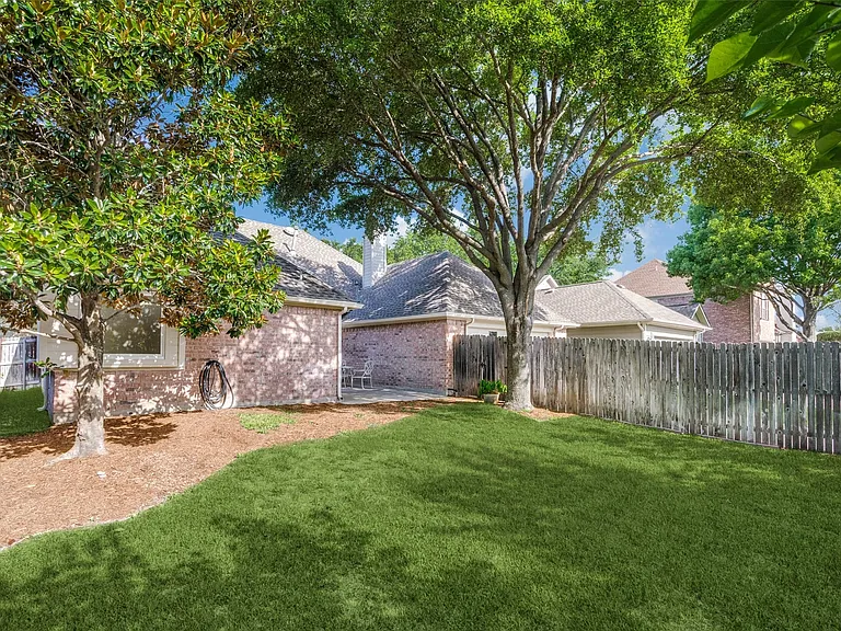 Fenced backyard with open patio