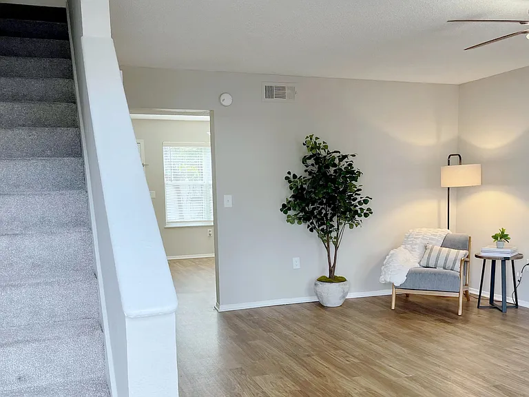 Unwind in fab living spaces where bright wood-style floors, dance under the glow of chic ceiling fans.