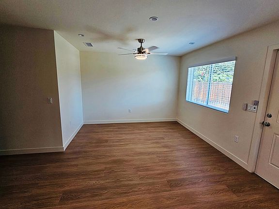 Living room area with ceiling fan and recessed lighting.