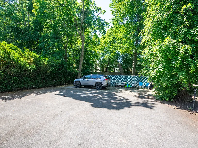 One assigned parking space located beside the lush, oasis-like backyard.