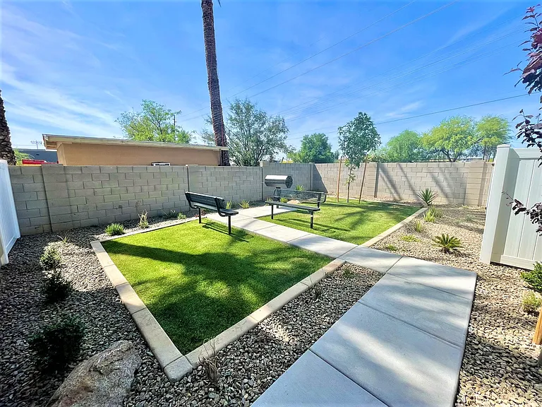 Grassy area with grill and seating.