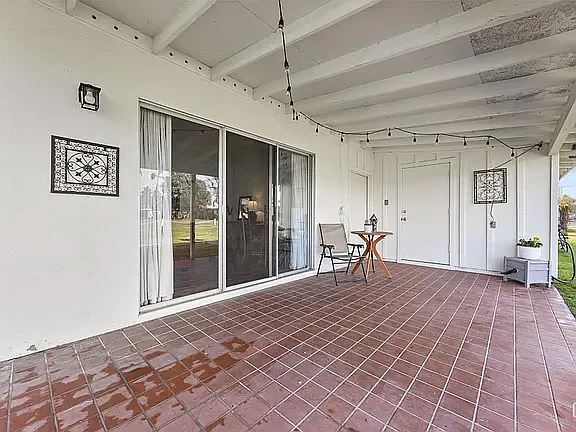 Patio overlooking golf course and door to laundry room