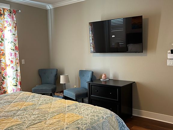 Top level Master bedroom with king size bed, TV and seating area.