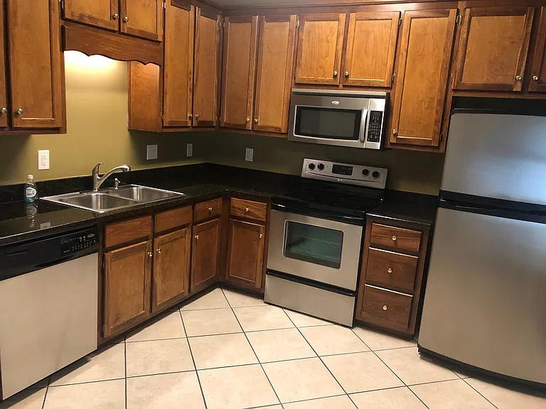 Modern kitchen with tile floors, stainless steel appliances, granite countertops, and lots of beautiful cabinets that offer plenty of storage.