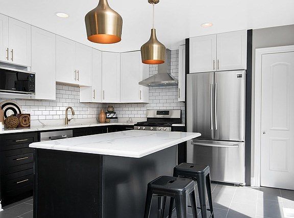 Updated kitchen with stainless steel appliances, quartz counters, a pantry, and an island - perfect 