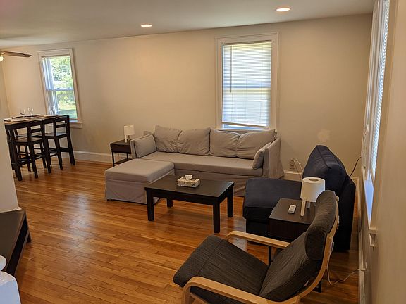 Sunny living room new trim, fresh paint, & refinished hardwood floors