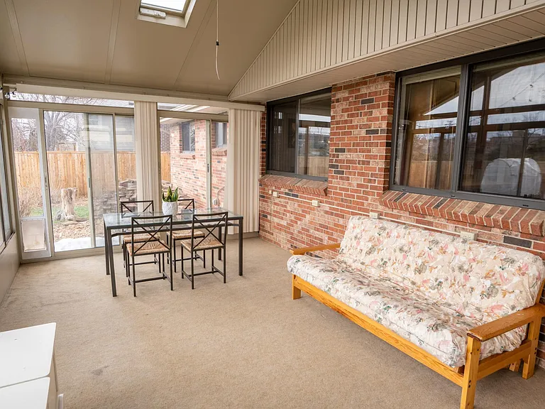 North-east view of the sun room. The window on the right is the kitchen window and the left window is in the dining room. The two windows seen outside are in the primary bathroom and bedroom.