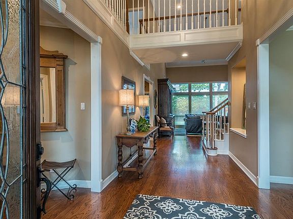 Foyer is tall and open with wood flooring. Formal dining is on the right.