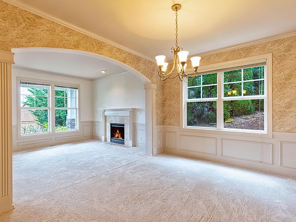Living room and dining room with lots of craftsman details: arched doorways, crown moulding & wainscoting
