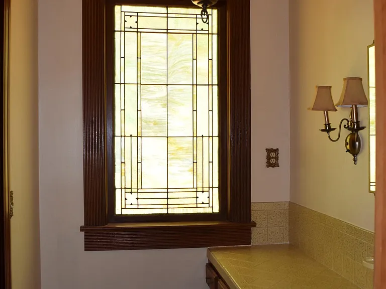 Stain Glass Window from First Methodist Church downtown Tuscaloosa, opening to left of lavatory for chair - make up area