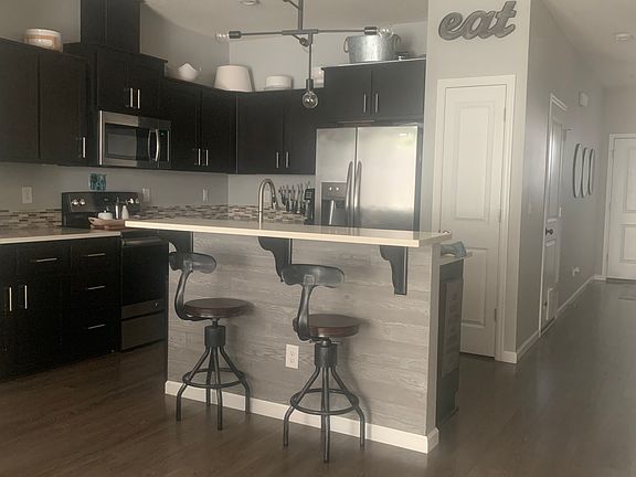 kitchen with bar,ss fridge, quartz counter tops, large open ss sink, pantry