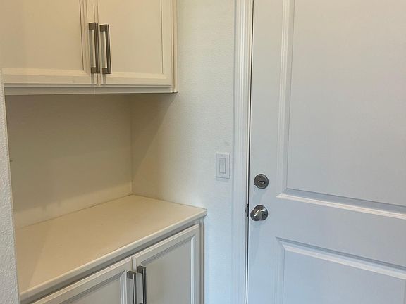 Foyer inside front door with cabinets, counters, door to 2-car garage and closet to the right (not shown here)