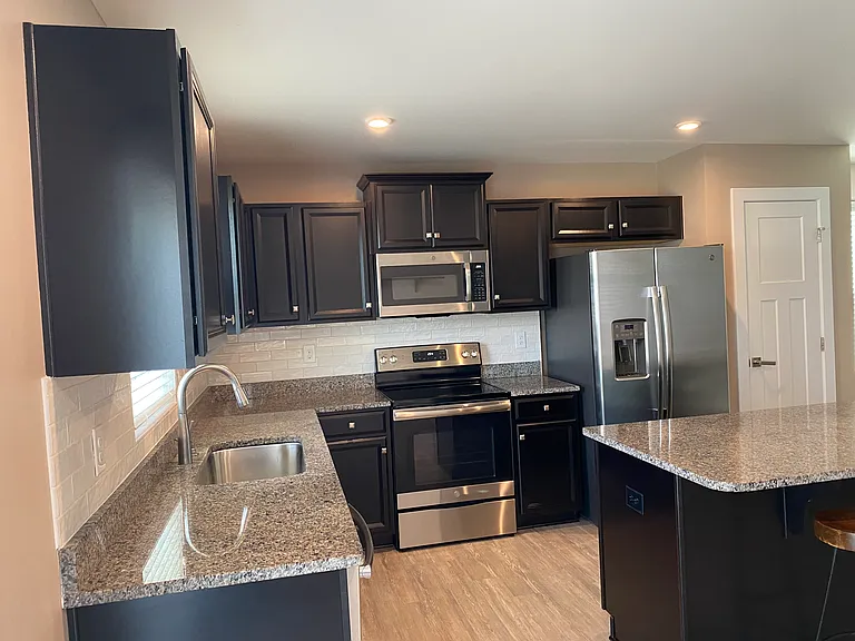 Kitchen with granite counter tops, tile back splash and pantry.