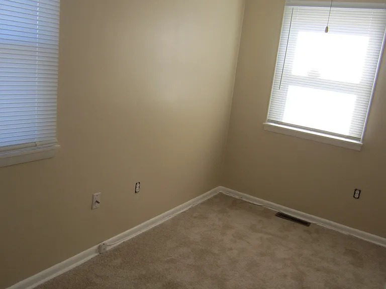 Mid size bedroom showing ceiling fan & new carpet but not the closet or entrance. Room is larger than the photo shows.
