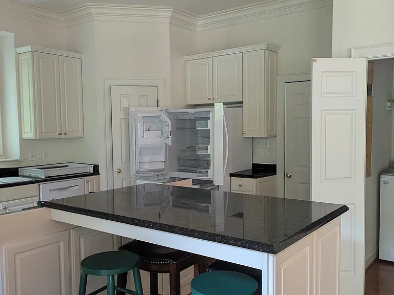 Kitchen island and refrigerator. Left is pantry, garage to right.