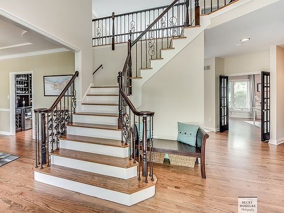 Grand 2-story foyer offers this stunning custom staircase & beautiful hardwood flooring!