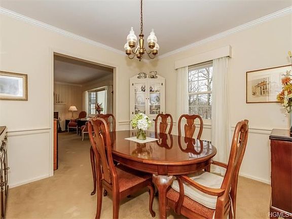 Formal Dining Room with lovely molding and chair rail.  Wood floors under carpeting