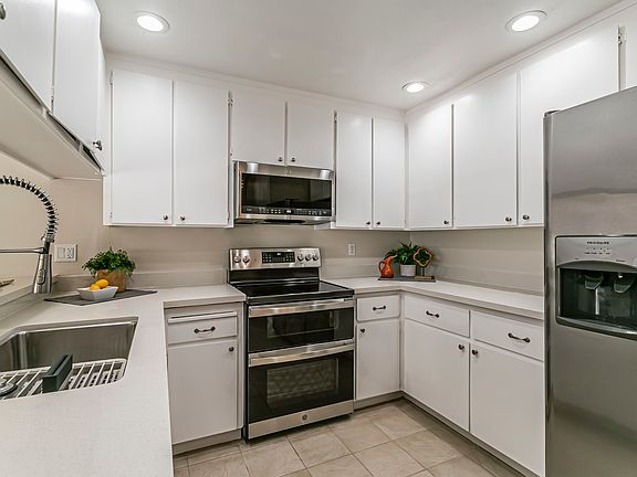 Updated kitchen w/new SS appliances, range, microwave, dishwasher & farm house sink. Quartz counters. Tile flooring.