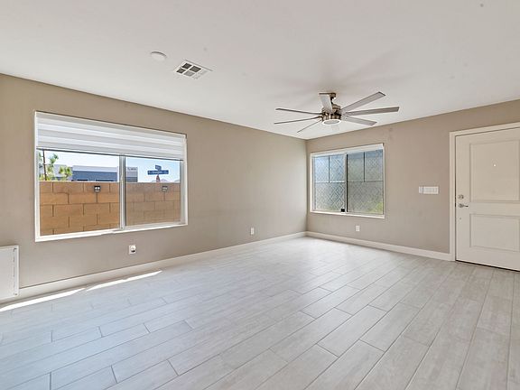 Bright Living Spaces: Natural light floods in through custom window coverings, creating an inviting ambiance in the expansive living and dining areas.