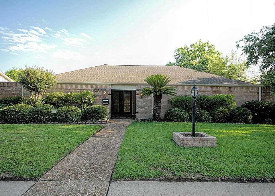 Front view of the lushly landscaped front yard and main entryway.