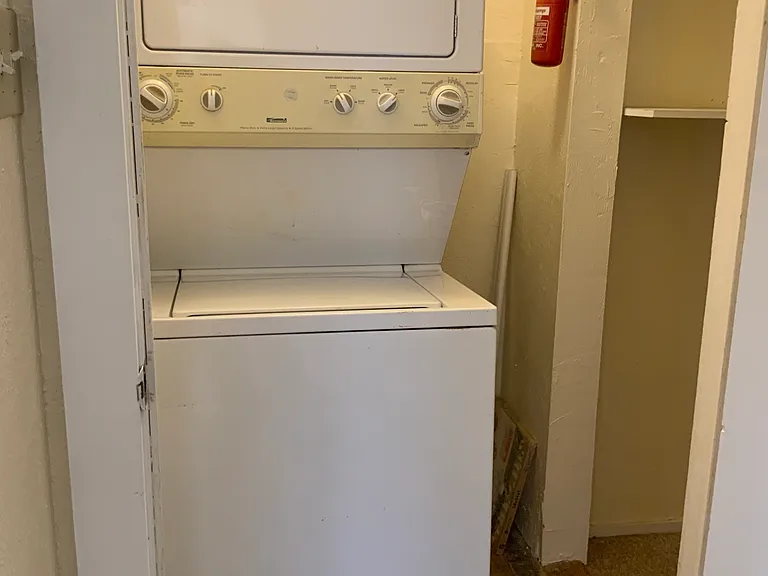 Stackable washer dryer next to the large storage closet.