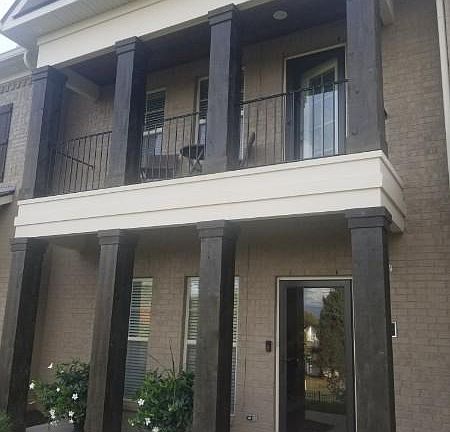 Townhome with wooden posts on both levels and balcony off master bedroom