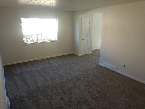 Living area wraps around to dining room with sliding glass door to private back yard