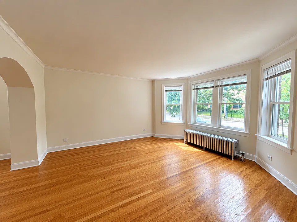 Spacious, sun-drenched living room with bay windows.