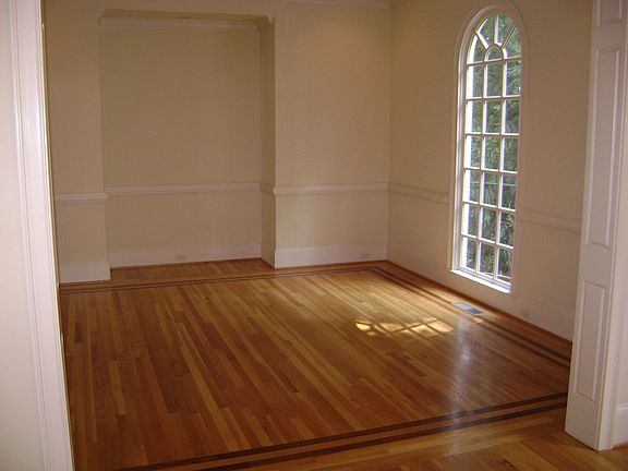 LARGE DINING ROOM HAS HARDWOOD FLOOR AND CHAIR RAILING. 