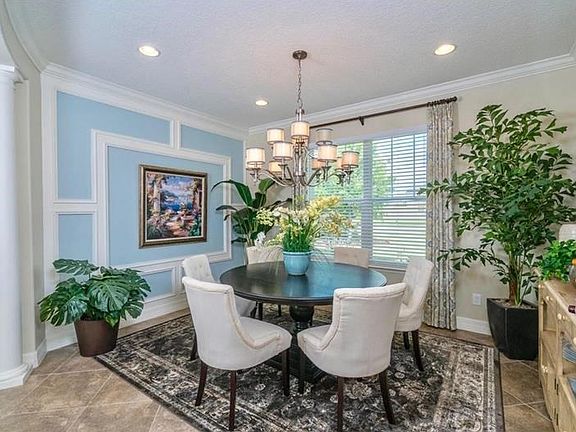 Entertain in style in this dining area with architectural design, crown molding and views of the landscape. Look at that beautiful chandelier.