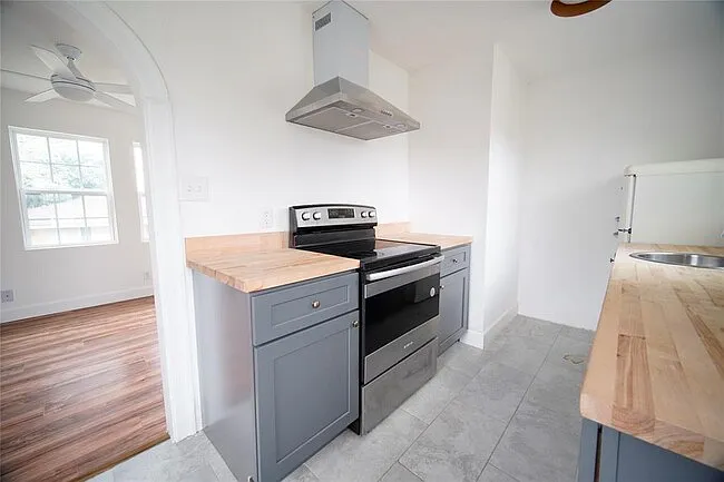 Full kitchen with stove, vent, dishwasher and fridge