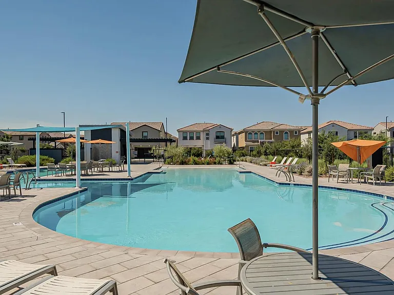 Resort-style outdoor pool area with ample loungers, shaded tables, and landscaped surroundings for relaxing or entertaining.