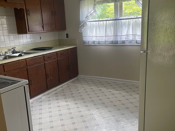 Kitchen with glass stop electric range and brand new refrigerator