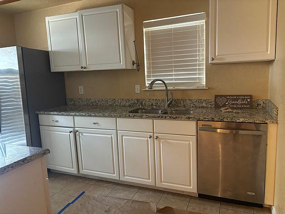 Kitchen with stainless steel appliances. Microwave, refrigerator, dishwasher, flattop convection oven.