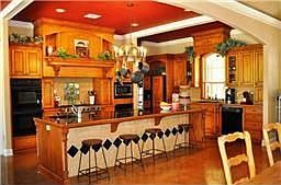 Gourmet kitchen with custom maple cabinetry, huge island breakfast bar, professional appliances.