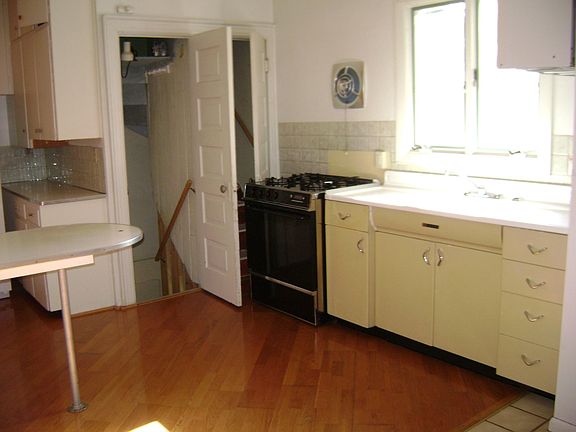Kitchen with stove and sink, doors to basement and attic