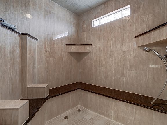 Huge master shower with granite seats