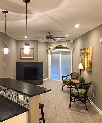 wood burning fire place has updated tile, the new doors to the covered patio have blinds inside the glass panels. Notice the molding detail work above the patio doors